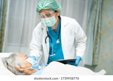 Asian doctor wearing face shield and PPE suit to check senior woman patient protect safety infection Covid-19 Coronavirus outbreak at quarantine nursing hospital ward. - Powered by Shutterstock