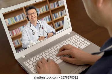 An Asian Doctor Who Is Remotely Consulting With A Patient. Telehealth Concept.