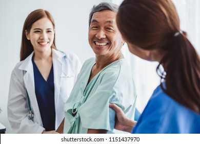 Asian doctor woman and nurse encourage disabled old man patient sitting on wheelchair at hospital, asian medical concept