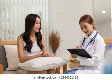 Asian doctor woman visited patient woman to diagnosis and check up health at home or private hospital. Female patient explain health problem and symptoms to doctor .Health care premium service at home - Shutterstock ID 2164351413