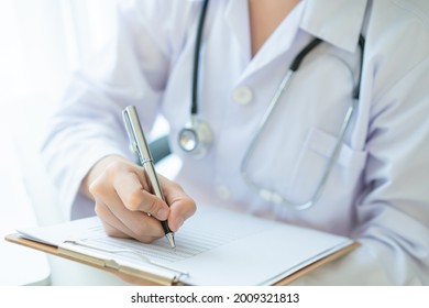 Asian Doctor Working In The Office In Hospital And Reviewing A Medication Report Close Up With Copyspace, Healthcare Worker Portrait. Female Doctor Examine A Medication Cure Diagnostic Report.