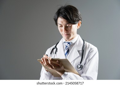 Asian Doctor Writing In Dark Background