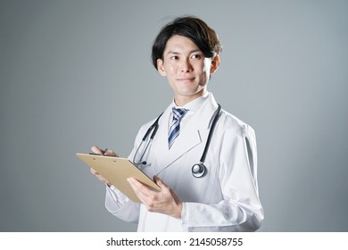 Asian Doctor Writing In Dark Background