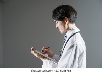 Asian Doctor Writing In Dark Background