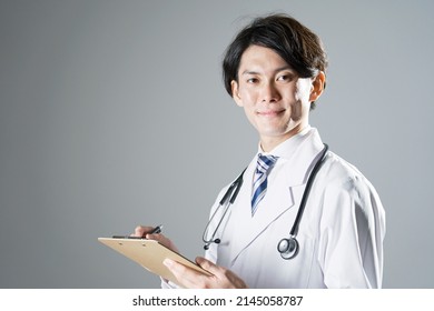 Asian Doctor Writing In Dark Background