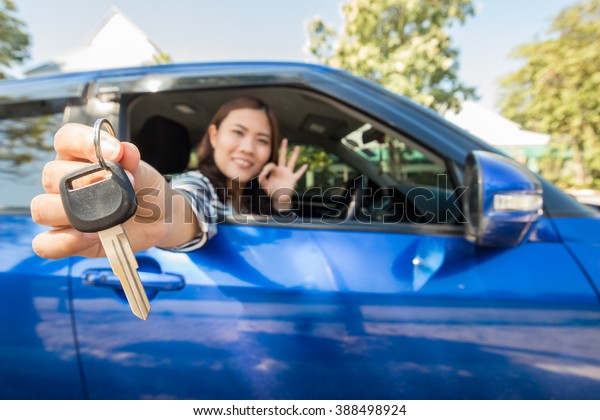 Asian driver woman\
smiling showing car keys