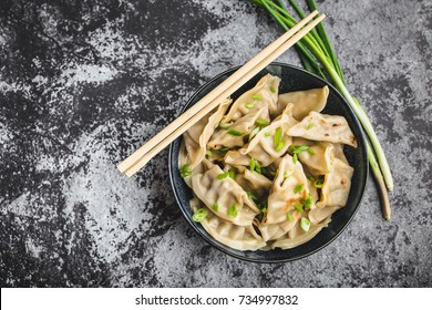 Asian Dumplings In Bowl, Chopsticks, Rustic Stone Background. Top View. Chinese Dumplings For Dinner. Closeup. Chinese Dumplings For Dinner/lunch. Traditional Asian/Chinese Cuisine. Overhead. Dim Sum 