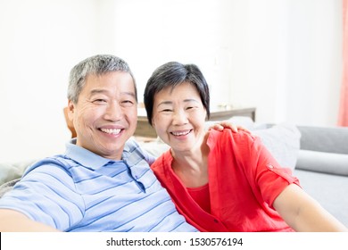 asian eldely couple smile to you happily at home