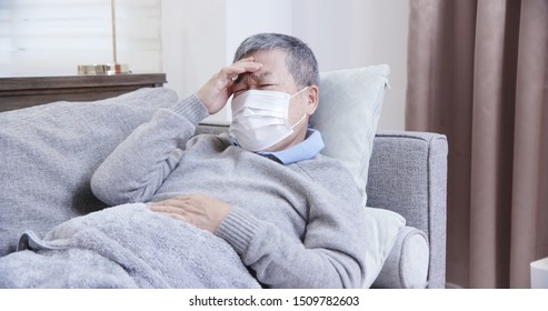 asian eldely sick man feel headache with mask lying on the sofa at home - Shutterstock ID 1509782603