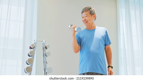 Asian Elder Man Lifts Dumbell In Gym