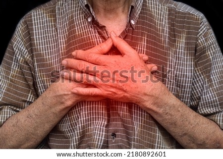 Asian elder man suffering from central chest pain. Chest pain can be caused by heart attack, myocardial infarct or ischemia, myocarditis, pneumonia, oesophagitis, stress, etc,.