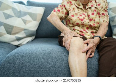 Asian Elder Woman Having A Critical Health Problem At Knee And Bone Joint, Woman Touching Or Holding At Knee. Elder Woman Getting Hurt And Injured At Her Leg.