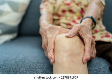 Asian Elder Woman Having A Critical Health Problem At Knee And Bone Joint, Woman Touching Or Holding At Knee. Elder Woman Getting Hurt And Injured At Her Leg.