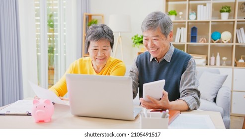 Asian Elderly Couple Discuss Retirement Plan Together With Laptop And Calculator At Home