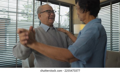 The Asian elderly couple gracefully swayed to the music as they romantically danced at home, their love and connection still strong despite the passing years - Powered by Shutterstock