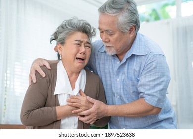 Asian Elderly Couple, Taking Care Of Health In Retirement, Elderly Asian Woman With Chest Pain From A Heart Attack.