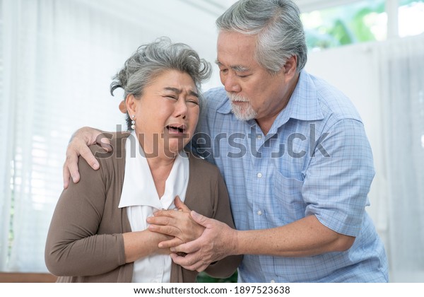 Asian elderly\
couple, Taking care of health in retirement, Elderly Asian woman\
with chest pain from a heart\
attack.