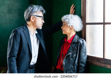 Asian Elderly Couple Talking In A Fashionable Room.