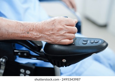 Asian elderly disability woman patient use joystick electric wheelchair in hospital. - Powered by Shutterstock