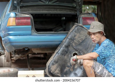 Asian Elderly Man Cleaning The Old Car Fuel Tank