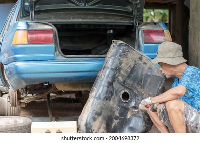 Asian Elderly Man Cleaning The Old Car Fuel Tank