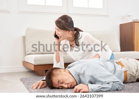 Asian elderly man collapsing due to sudden illness in the living room