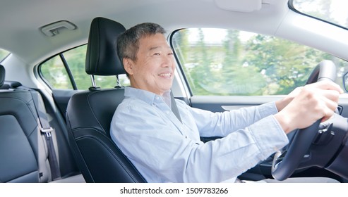 Asian Elderly Man Driving Happily In The Car On Highway