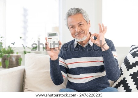 Asian elderly man having an electronic calculator,smile