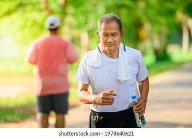 Asian Elderly Man Or Senior Runner Smile Happily In Jogging Outdoor And Walking Workouts In The Park