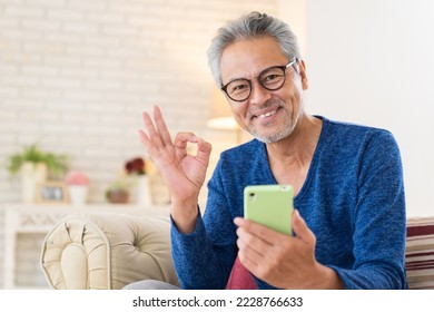 Asian elderly man who uses smart phone,