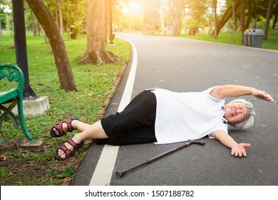 Asian Elderly People Stumbled Legs Myself Or Tripped Over Something,sick Senior Woman Skid,falling Down To The Floor Because Of Dizziness,faint,suffering From Illness,headache,hypertension In Park