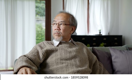 Asian Elderly Senior Male Or Depressed Grandpa At Nursing Home Living Room On Quarantine Looking Out Window Feeling Sad Missing Unhappy Thoughtful In Mental Health Care In Older People.