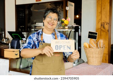 Asian elderly, senior, pensioner, female open cafe restaurant small business at home town after retirement, healthy strong 60s woman happy lifestyle wearing apron working as barista waitress worker - Powered by Shutterstock