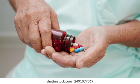 Asian elderly woman holding pill drug in hand, strong healthy medical concept.  - Powered by Shutterstock