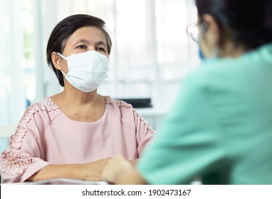 Asian Elderly Woman Patient Wearing Protective Face Mask Talking Consulting And Giving Information With Female Doctor Or Nurse In Medical Office Clinic Or Hospital