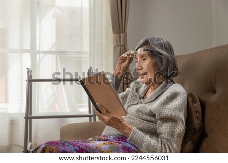 Asian elderly woman is reading a book for relax at nursing home.