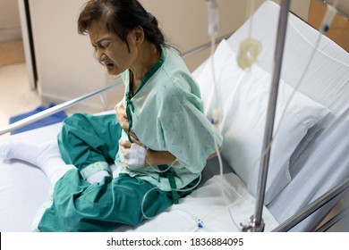 Asian Elderly Woman With A Stomach Ache Holding Her Belly,abdominal Disease,intestinal Infection Problems,acute Enteritis,cancer Or Tumors,patient With Saline Solution During Treatment In A Hospital