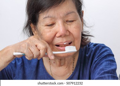 Asian Elderly Woman Trying Use Toothbrush ,hand Tremor . Dental 