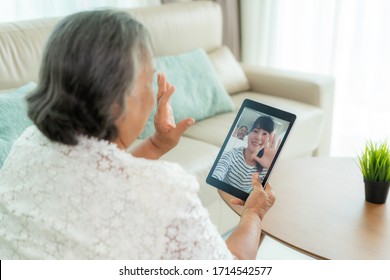 Asian Elderly Woman Virtual Happy Hour Meeting And Talking Online Together With Her Daughter In Video Conference With Tablet For A Online Meeting In Video Call For Social Distancing.
