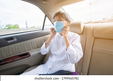 Asian elderly woman wear face mask in car or taxi prevent from covid-19 pandemic illness crisis. New normal and social distancing concept 