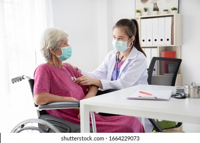 Asian Elderly woman wearing surgical mask while visit a doctor in hospital .