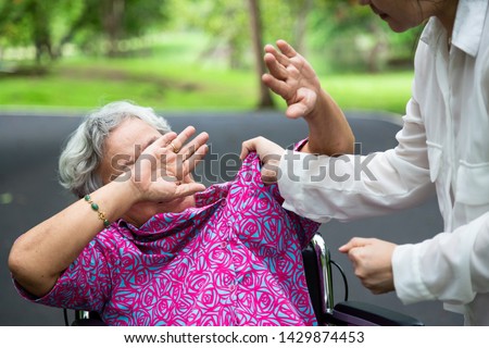 Asian elderly woman were physically abused ,attacking in outdoor park,angry young woman raised punishment fist,stop physical abuse senior people,caregiver,family stop violence and aggression concept