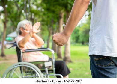 Asian Elderly Woman In Wheelchair Were Physically Abused,attacking In Outdoor,stop Physical Abuse Senior People,angry Man Or Caregiver Raised Punishment Fist,stop Violence And Aggression Concept