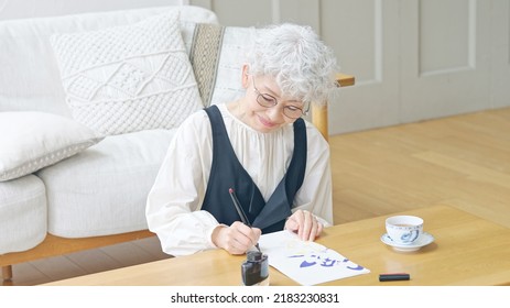 Asian Elderly Woman Writing A Letter.