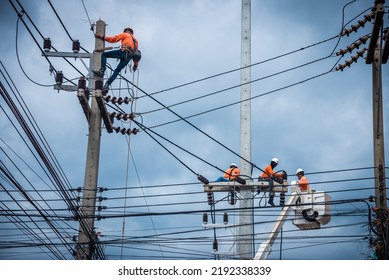Asian electricians are climbing on electric poles to install and repair power lines. - Shutterstock ID 2192338339
