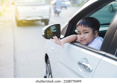 Asian Elementary Boy Waving Goodbye In Car Off To School.