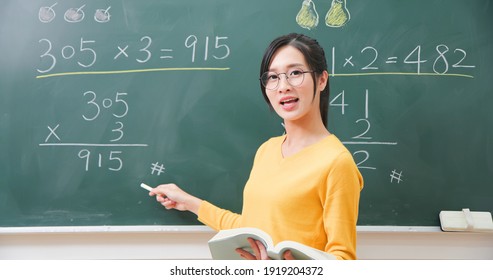 Asian Elementary School Female Teacher Teach Math Online Through Webcam In Classroom