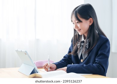 asian elementary school girl studying with tablet in classroom - Powered by Shutterstock