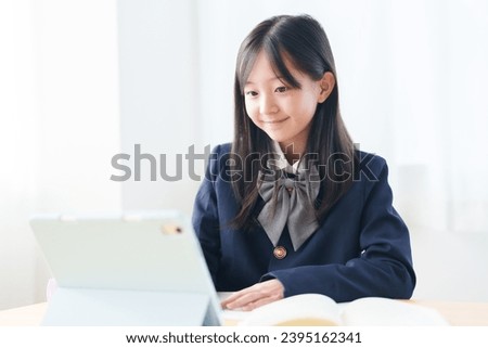 asian elementary school girl studying with tablet in classroom