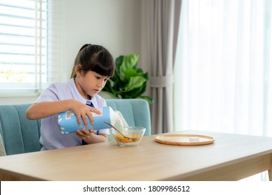 Asian Elementary School Student Girl In Uniform Eating Breakfast Cereals With Milk In Morning School Routine For Day In Life Getting Ready For School.